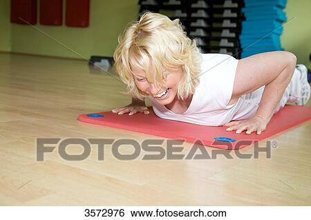 Mature woman exercising on gymnastics mat in gym View Large Photo Image Stock Photograph - Mature woman exercising on gymnastics mat in gym . Fotosearch