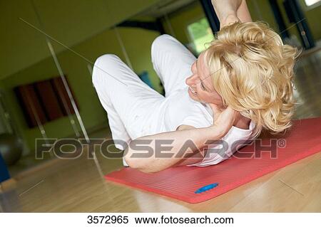 Mature woman exercising on gymnastics mat in gym View Large Photo Image Stock Photography - Mature woman exercising on gymnastics mat in gym . Fotosearch