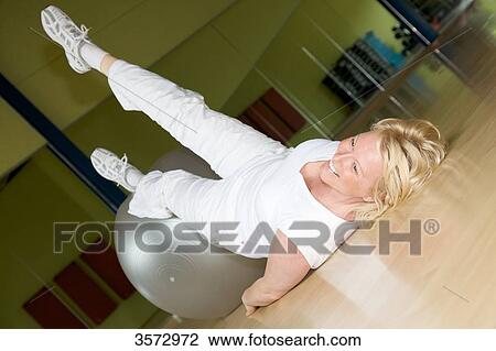 Mature woman exercising with fitness ball in gym View Large Photo Image Stock Image - Mature woman exercising with fitness ball in gym . Fotosearch