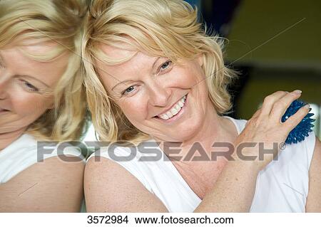 Mature woman massaging her shoulder View Large Photo Image Picture - Mature woman massaging her shoulder . Fotosearch