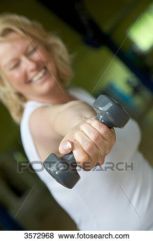 Mature woman weight lifting in gym View Large Photo Image Stock Photo - Mature woman weight lifting in gym . Fotosearch