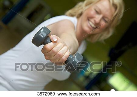 Mature woman weight lifting in gym View Large Photo Image Stock Photo - Mature woman weight lifting in gym . Fotosearch
