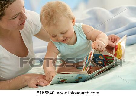 Stock Image - Mother and baby with picture book . Fotosearch