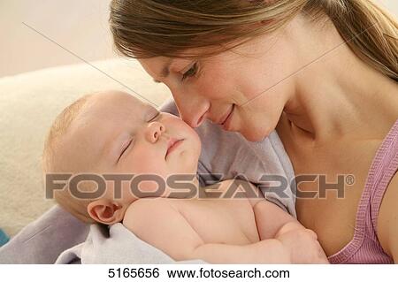 Mother holding sleeping baby View Large Photo Image Stock Photograph - Mother holding sleeping baby . Fotosearch