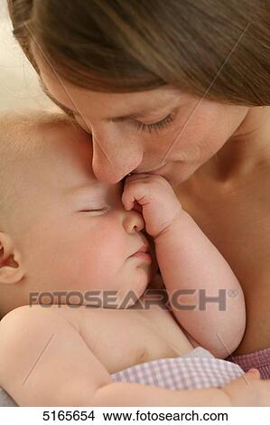 Picture - Mother kissing sleeping baby . Fotosearch