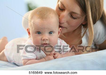 Stock Photo - Mother lying with baby on blanket . Fotosearch