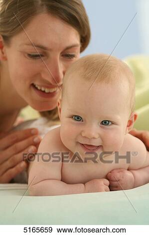 Mother lying with baby on blanket View Large Photo Image Stock Photo - Mother lying with baby on blanket . Fotosearch