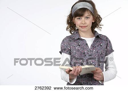 Portrait of girl holding book and smiling View Large Photo Image Stock Image - Portrait of girl holding book and smiling . Fotosearch