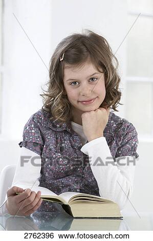 Portrait of girl holding book and smiling View Large Photo Image Stock Photograph - Portrait of girl holding book and smiling . Fotosearch
