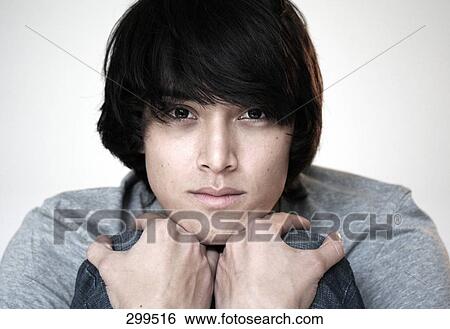 Stock Photograph - Portrait of young man looking serious . Fotosearch