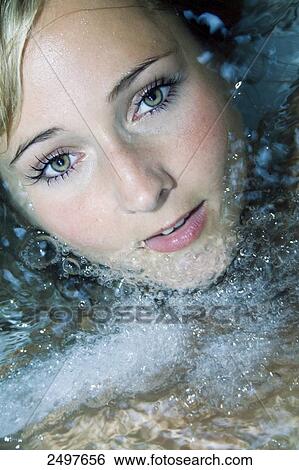 Stock Photograph - Portrait of young woman in jacuzzi . Fotosearch