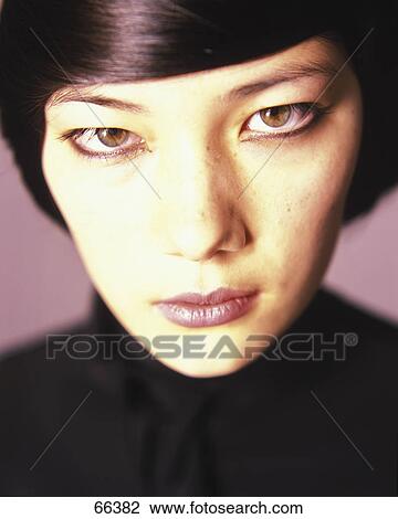 Stock Image - Portrait of young woman looking serious . Fotosearch