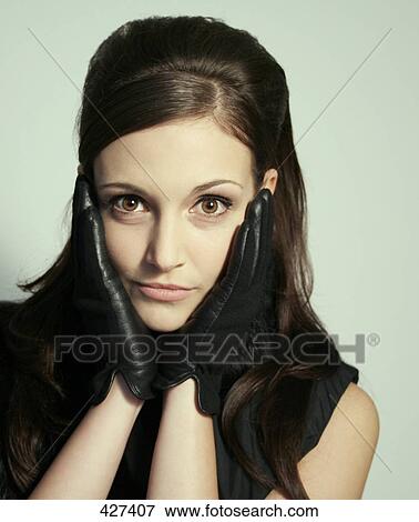 Stock Photo - Portrait of young woman wearing leather gloves . Fotosearch