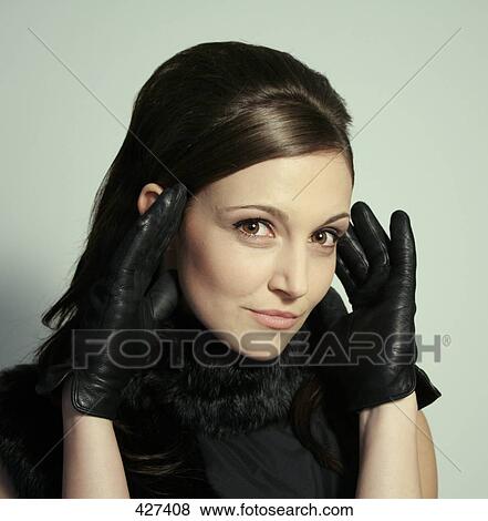 Stock Photo - Portrait of young woman wearing leather gloves . Fotosearch