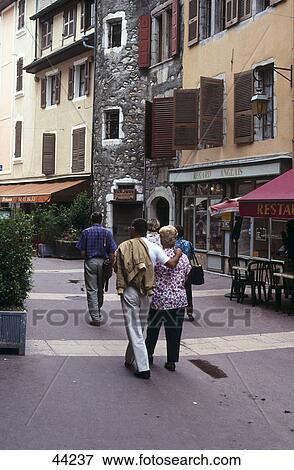Stock Photo - Rear view of tourists on shopping road, Annecy, France . Fotosearch