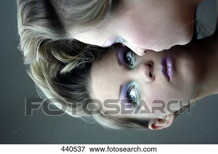 Stock Photo - Reflection of young woman in mirror . Fotosearch