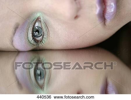 Stock Photograph - Reflection of young woman in mirror . Fotosearch