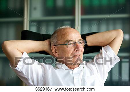 Relaxed senior man in home office View Large Photo Image Stock Photo - Relaxed senior man in home office . Fotosearch
