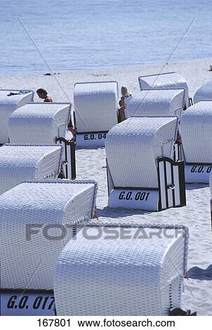 Stock Image - Roofed wicker beach chairs on beach, Germany . Fotosearch