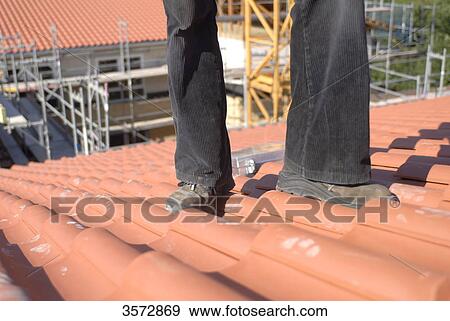 Roofer standing on roof, lower section View Large Photo Image Stock Photo - Roofer standing on roof, lower section . Fotosearch