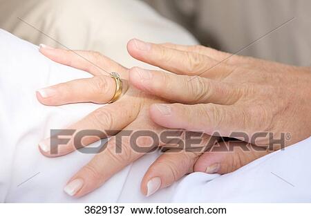 Stock Photo - Senior couple hand in hand, close-up . Fotosearch