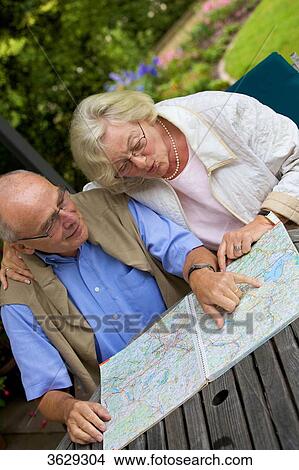 Picture - Senior couple on terrace looking in road map . Fotosearch