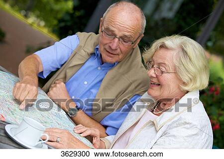 Senior couple on terrace looking in road map View Large Photo Image Stock Image - Senior couple on terrace looking in road map . Fotosearch