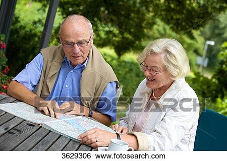 Senior couple on terrace looking in road map View Large Photo Image Stock Photograph - Senior couple on terrace looking in road map . Fotosearch
