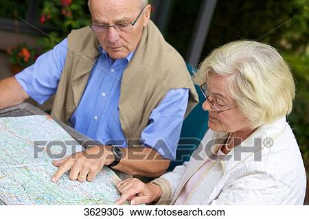 Senior couple on terrace looking in road map View Large Photo Image Stock Photography - Senior couple on terrace looking in road map . Fotosearch