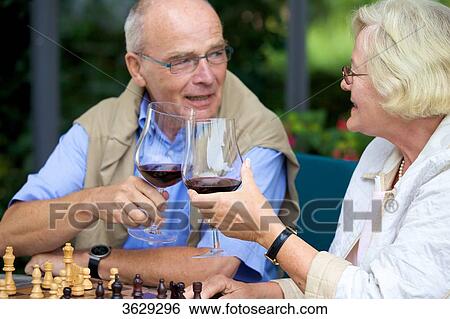 Senior couple on terrace playing chess and drinking red wine View Large Photo Image Stock Photograph - Senior couple on terrace playing chess and drinking red wine . Fotosearch
