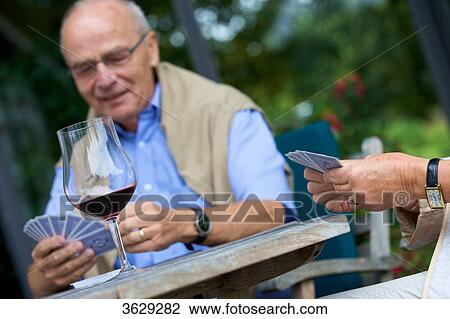 Senior couple playing cards and drinking red wine View Large Photo Image Stock Image - Senior couple playing cards and drinking red wine . Fotosearch