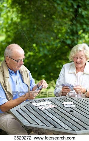 Stock Image - Senior couple playing cards on the terrace . Fotosearch