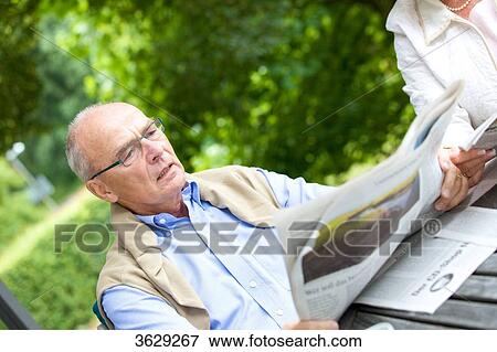 Senior couple reading newspaper on the terrace View Large Photo Image Stock Photo - Senior couple reading newspaper on the terrace . Fotosearch