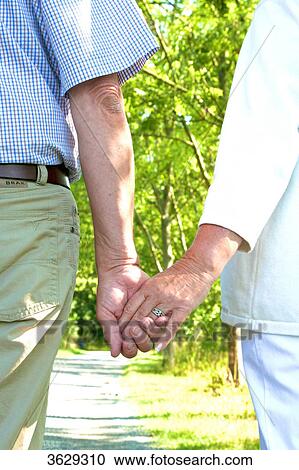 Senior couple walking hand in hand View Large Photo Image Stock Image - Senior couple walking hand in hand . Fotosearch