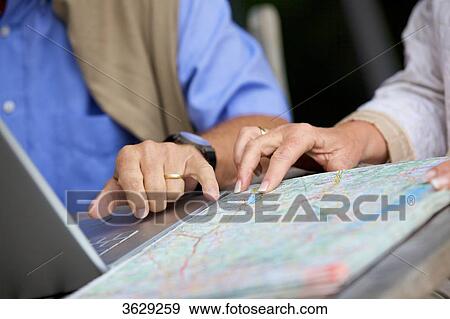 Senior couple with laptop and road map, close-up View Large Photo Image Stock Photo - Senior couple with laptop and road map, close-up . Fotosearch