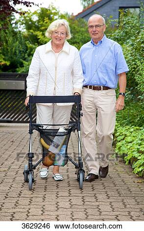 Senior couple with walking frame making purchases View Large Photo Image Stock Photograph - Senior couple with walking frame making purchases . Fotosearch