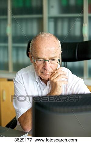 Senior man on cell phone in home office View Large Photo Image Stock Photo - Senior man on cell phone in home office . Fotosearch