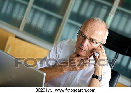 Senior man on cell phone in home office View Large Photo Image Stock Photography - Senior man on cell phone in home office . Fotosearch