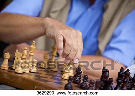 Stock Image - Senior man playing chess, close-up . Fotosearch