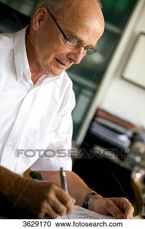 Senior man reading document at desk View Large Photo Image Stock Image - Senior man reading document at desk . Fotosearch