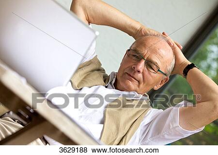 Senior man using laptop on terrace View Large Photo Image Stock Photo - Senior man using laptop on terrace . Fotosearch