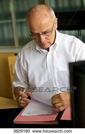 Stock Image - Senior man working in home office . Fotosearch