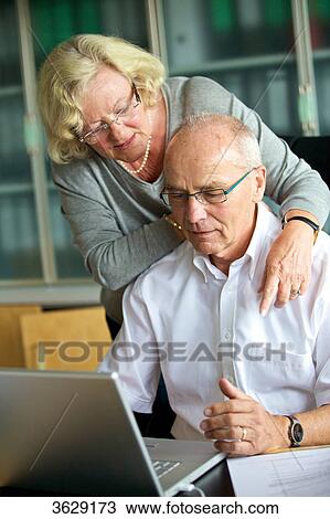 Senior woman embracing man at desk View Large Photo Image Stock Image - Senior woman embracing man at desk . Fotosearch