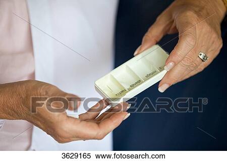 Stock Photography - Senior woman holding pill box, close-up . Fotosearch