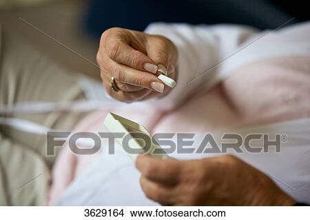Picture - Senior woman taking pill, close-up . Fotosearch