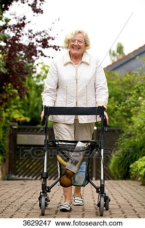 Stock Photo - Senior woman with walking frame making purchases . Fotosearch