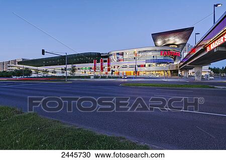 Stock Image - Shopping mall lit up at dusk, Eastgate, Marzahn, Berlin, Germany . Fotosearch