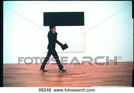 Side profile of businesswoman talking on mobile phone while walking View Large Photo Image Stock Photo - Side profile of businesswoman talking on mobile phone while walking . Fotosearch