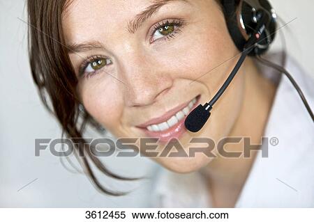 Stock Photography - Smiling woman wearing headset, portrait . Fotosearch