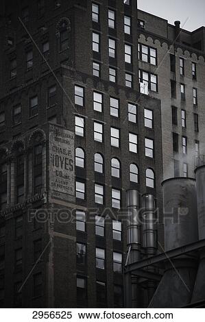 Stock Photography - Smoking chimneys in front of old building in the 34th Street, New York City, USA . Fotosearch